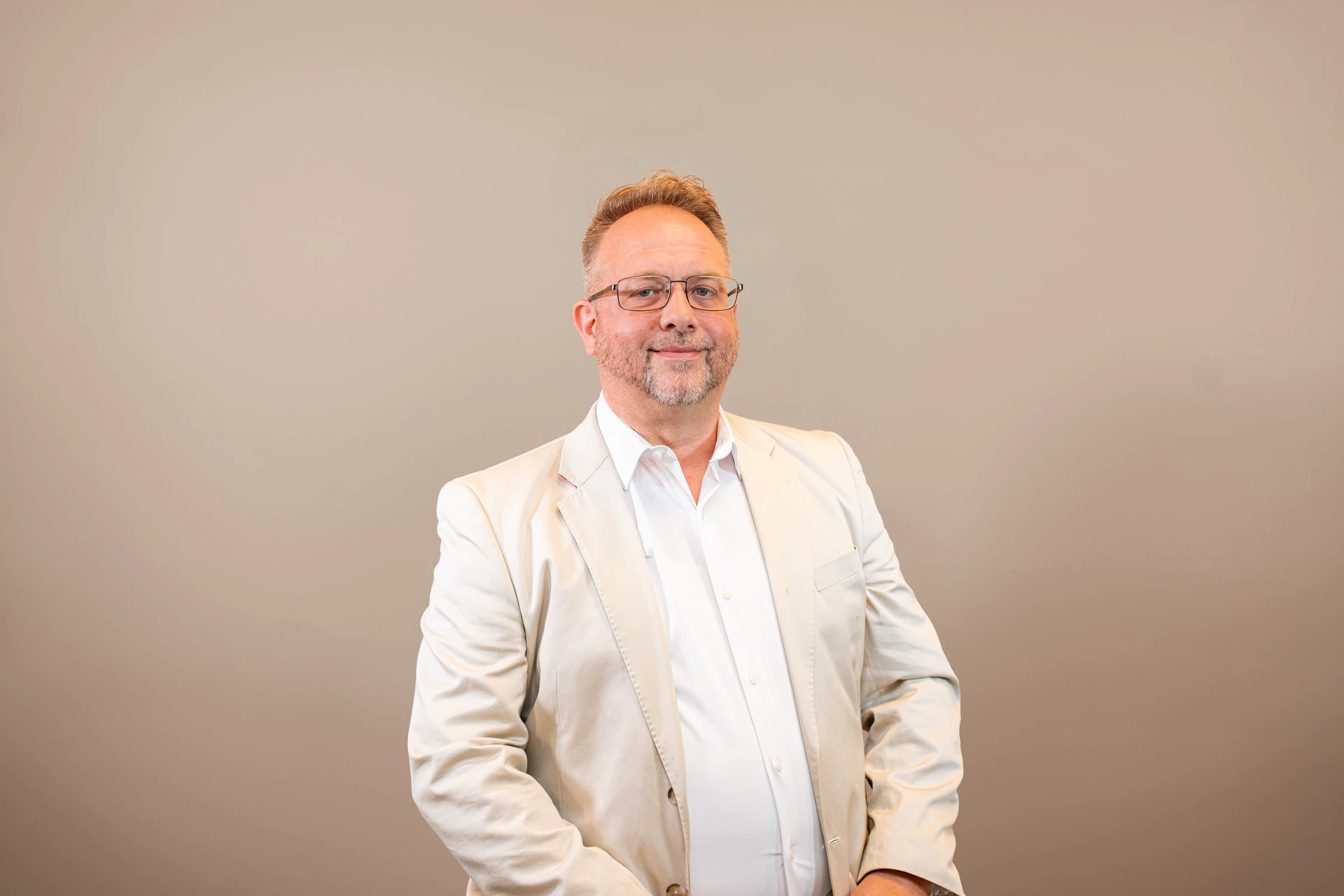 Man in beige blazer and glasses portrait