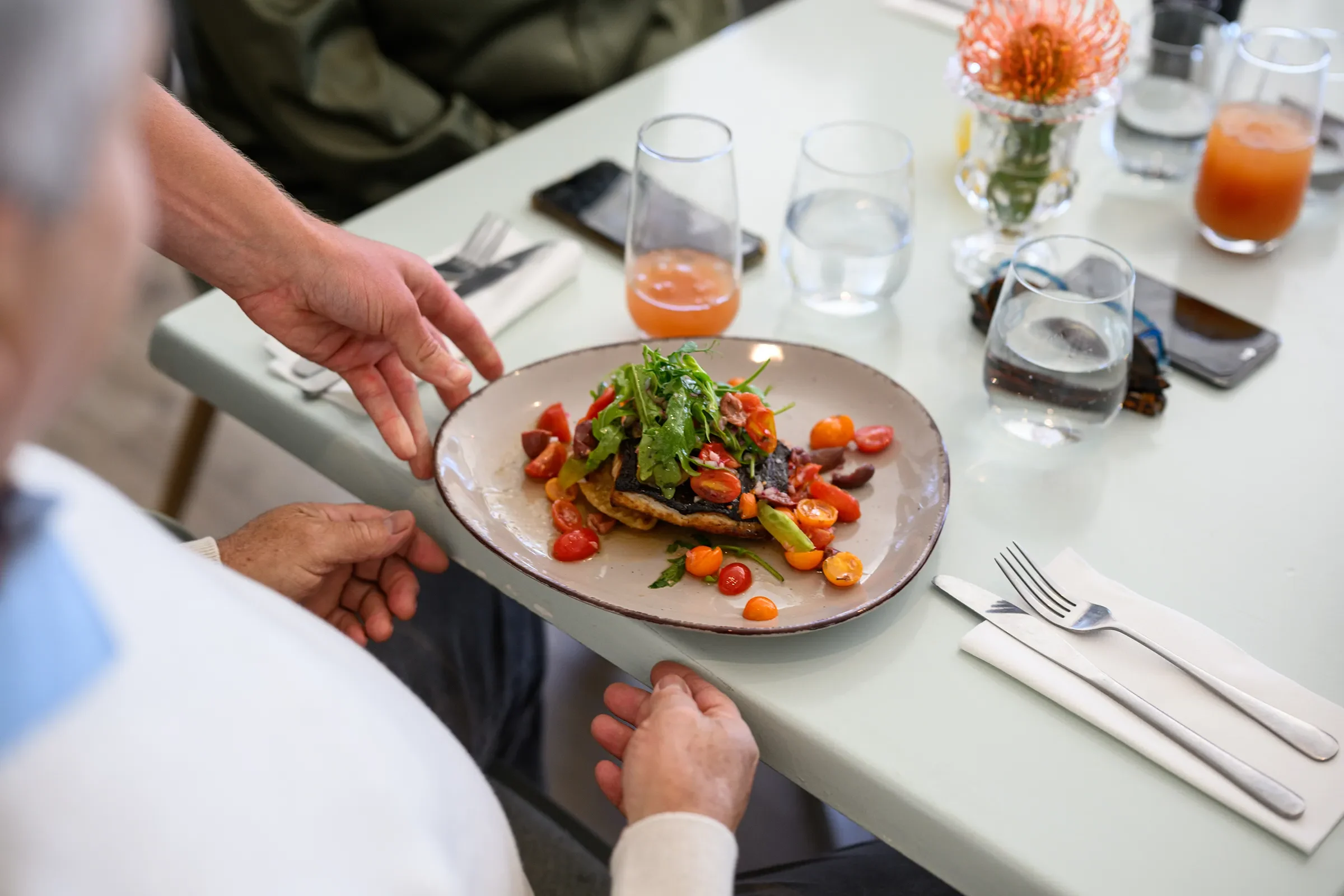 Plated salmon with greens on restaurant table